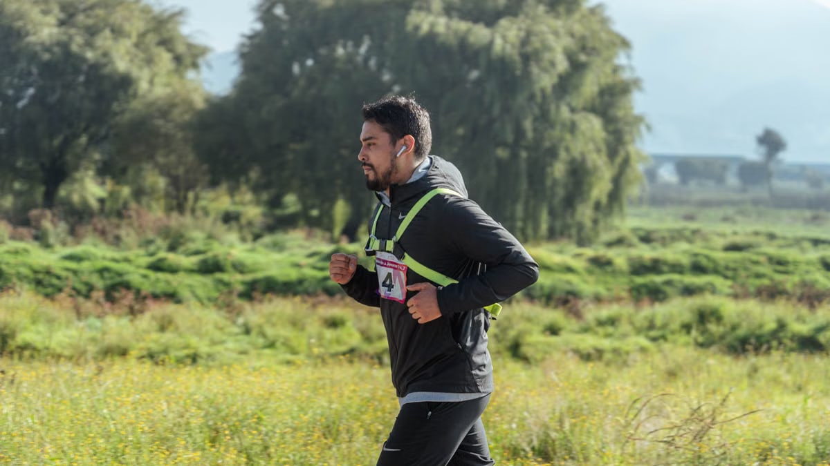 Man jogging in a lush park setting, engaging in fitness and exercise.